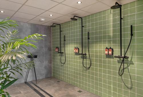 een badkamer met een douche met groene tegels bij De Hoeven in Veessen