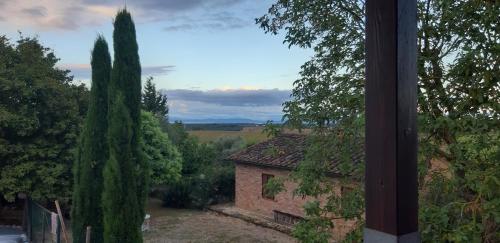 Blick auf ein Haus und Bäume aus dem Fenster in der Unterkunft Casale dell'Assiolo Bed and Breakfast in Petrignano sul Lago