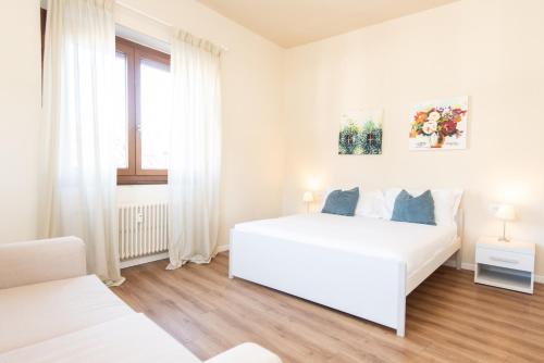 una camera bianca con un letto bianco e una finestra di Donatello Apartments by Firenze Prestige a Firenze