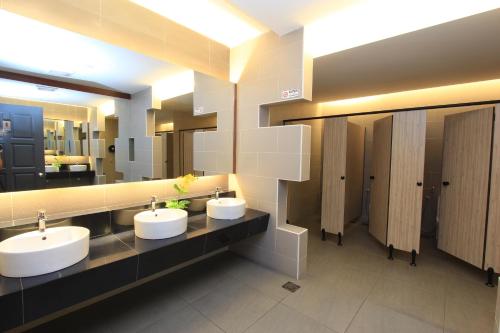 a bathroom with three sinks and a large mirror at Ipoh Downtown Hotel in Ipoh