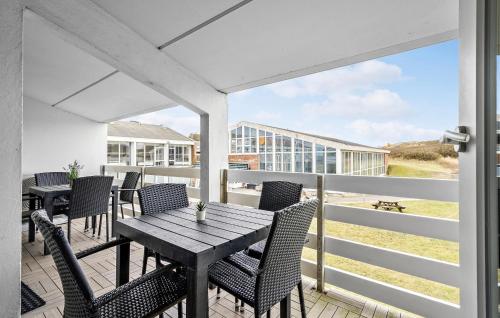 a patio with a wooden table and chairs on a balcony at Stunning Apartment In Ringkøbing in Ringkøbing