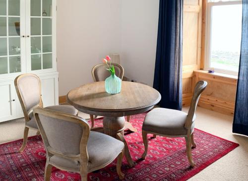 a dining room table and chairs with a vase on it at Sandbankhouse Campbeltown in Campbeltown