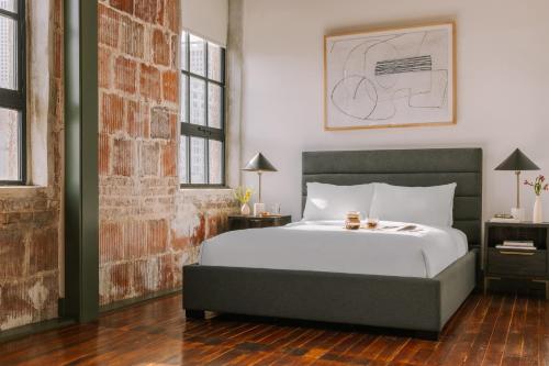 sypialnia z łóżkiem i ceglaną ścianą w obiekcie Sonder The Schaeffer w Nowym Orleanie