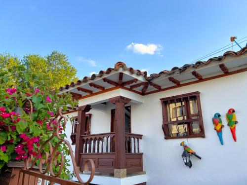 Casa con balcón y pájaros en la pared en CASA VACACIONAL SAN MARCOS, en Villa de Leyva