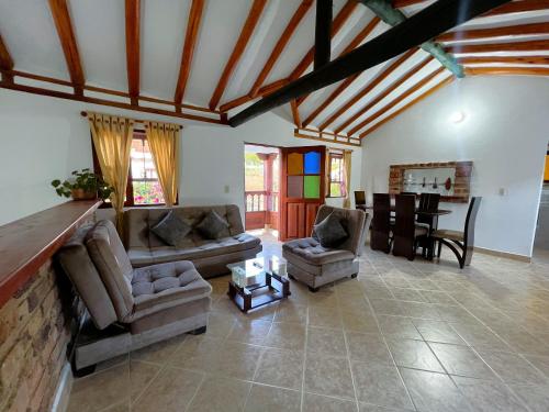 Sala de estar con 2 sofás y mesa en CASA VACACIONAL SAN MARCOS, en Villa de Leyva