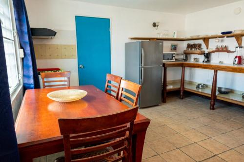 cocina con mesa de madera y nevera en Beachfront Suite 7 Atabey, en Vieques