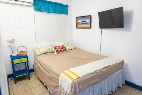 1 dormitorio con 1 cama y TV de pantalla plana en Beachfront Suite 7 Atabey, en Vieques