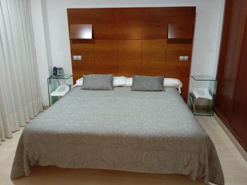 1 dormitorio con 1 cama grande y cabecero de madera en Nap Oviedo, en Oviedo