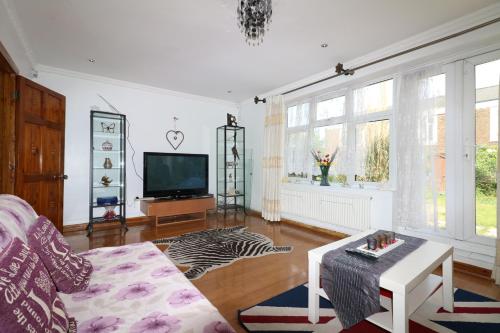 a living room with a couch and a tv at 3 Bedroom House-Garden-Stratford-Olympic Park in London