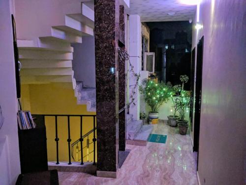 a hallway with stairs and potted plants in a building at mye Home stay near golden temple in Amritsar