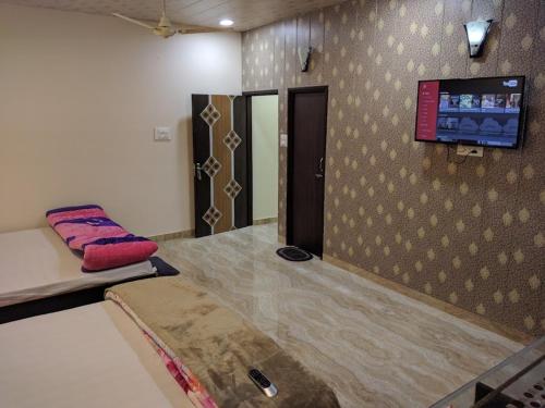a room with a bed and a flat screen tv on the wall at MYE Home stay near golden temple in Amritsar