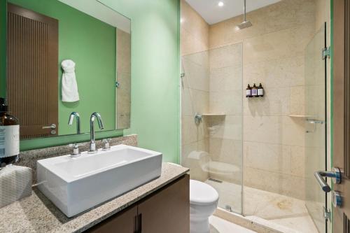 a bathroom with a white sink and a shower at Stylish Peninsula Golf 3BR Oasis with Pool in Nuevo Vallarta