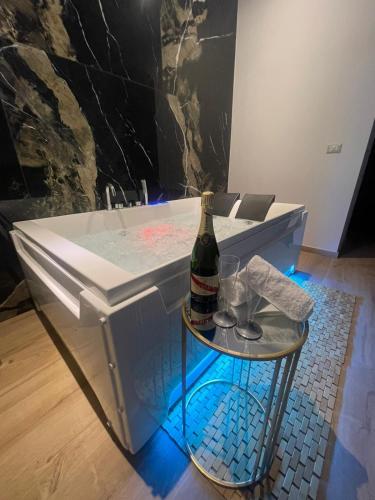 - un lavabo dans la salle de bains avec une bouteille de champagne et des verres dans l'établissement Relax Apartment 39, à Crotone