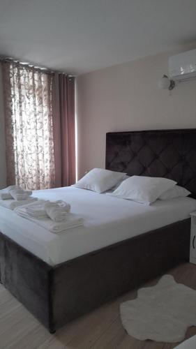 una camera da letto con un grande letto con lenzuola bianche di Nada's room with terrace a Kotor (Cattaro)