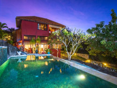 a house with a swimming pool in front of a house at Canang Sari Uluwatu Villas Bali in Uluwatu