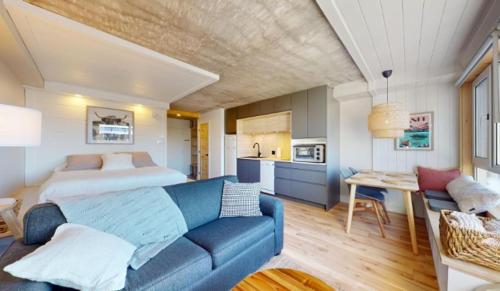 a living room with a blue couch and a bed at Hébergement Mont-Ste-Anne Condos in Beaupré