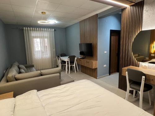 une chambre d'hôtel avec un lit et une salle à manger dans l'établissement Apartament Amel, à Pogradec