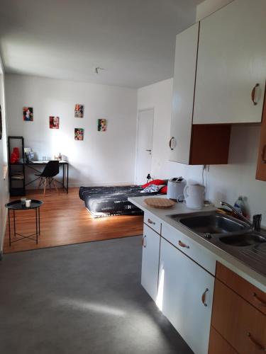 une cuisine avec des armoires blanches et un évier dans l'établissement Logement entier à Gannat, à Gannat