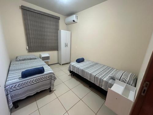 a room with two beds and a window in it at Apt. Aconchegante in Araguari