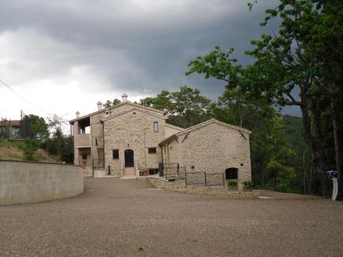 een oud stenen gebouw met een hek ervoor bij La Collina Con Gli Ulivi in Perugia