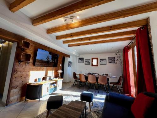 a kitchen and living room with a table and chairs at Chalet des Grangettes in LʼHuez