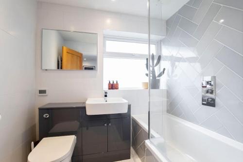uma casa de banho com um lavatório, um WC e um espelho. em Stunning 3 Bed Home in Gloucester em Down Hatherley