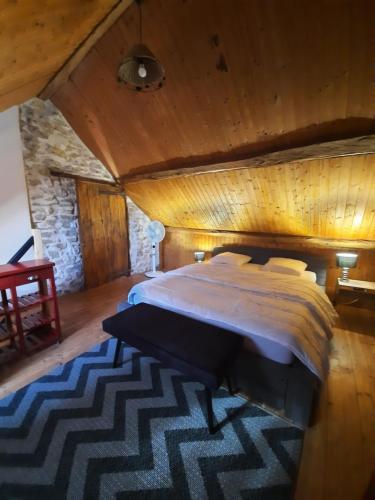een slaapkamer met een groot bed en een houten plafond bij gîte des 2 Lions in Murs-et-Gélignieux