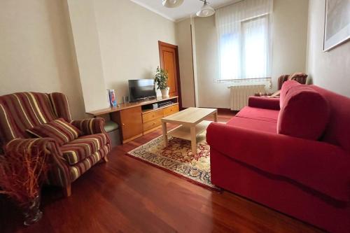 sala de estar con sofá rojo y 2 sillas en Casa PilarCasco Viejo Wifi, en Bilbao