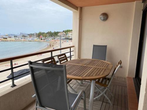 une table et des chaises sur un balcon avec vue sur la plage dans l'établissement Le plus bel emplacement des Lecques ! 3p vue mer, à Saint-Cyr-sur-Mer