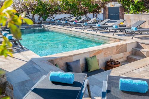 una piscina infinita con sillas y mesas en un complejo en Villa Shangri-La by Algarve Vacation, en Albufeira