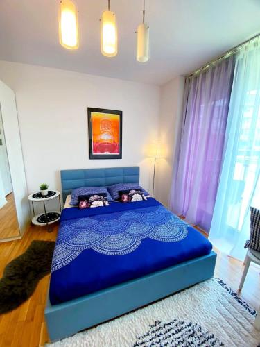 a bedroom with a blue bed with purple curtains at HomeComfort Apartament Gulia in Warsaw