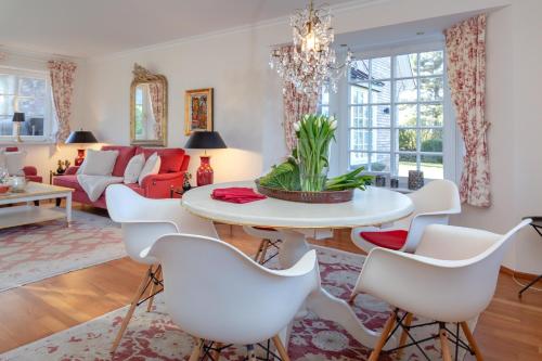 un soggiorno con tavolo bianco e sedie bianche di Haus Traumzeit Family a Braderup