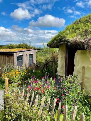 a garden with flowers in front of a hut at Panorama Peace Nature in Castlewellan