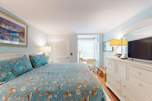 a bedroom with a large bed and a flat screen tv at 13104 Pelican Watch in Seabrook Island