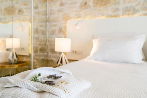 a bed with a white blanket and flowers on it at PARGA Villas Collection in Parga