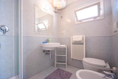 een badkamer met een wastafel, een toilet en een spiegel bij Camping Bungalow Lido in Capoliveri