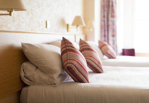 Habitación de hotel con 2 camas y almohadas en Imperial Hotel, en Ilfracombe