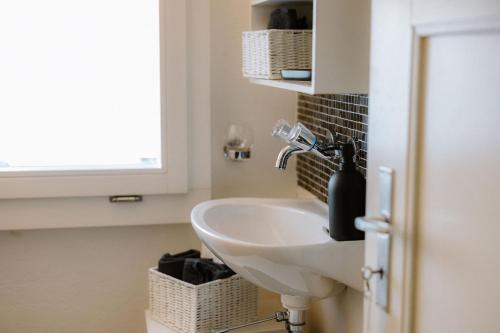 a bathroom with a sink and a window at Bijou Niesenblick - traumhafter Seeblick - nahe Interlaken - idyllisch in Merligen