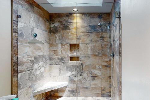 uma casa de banho com um chuveiro e uma parede de pedra em 2258 Rolling Dunes em Seabrook Island