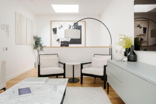 uma sala de estar branca com uma mesa e cadeiras em Luxury Central Mayfair Townhouse with A/C 3BR 3BA em Londres