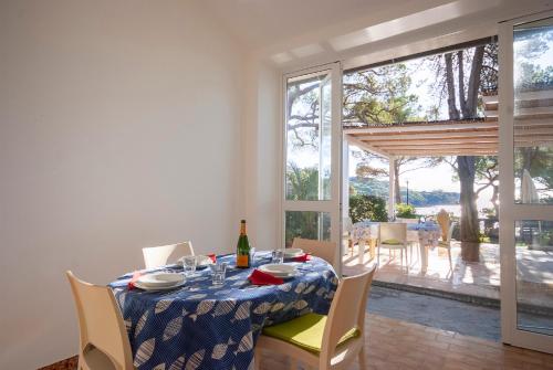 a dining room with a table with a bottle of wine at Camping Bungalow Lido in Capoliveri