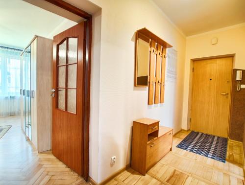 a hallway with a wooden door and a wooden floor at Mieszkanie w Centrum in Białystok