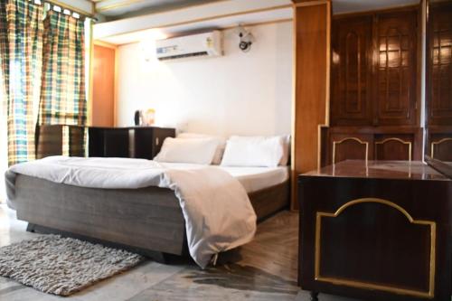 a bedroom with a bed and a dresser in it at Kajal's Home stay in Siliguri