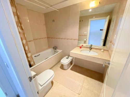 uma casa de banho com um WC, um lavatório e um espelho. em Apartamento en Mascarat Beach, Urb Oasis Beach 1 em Altea