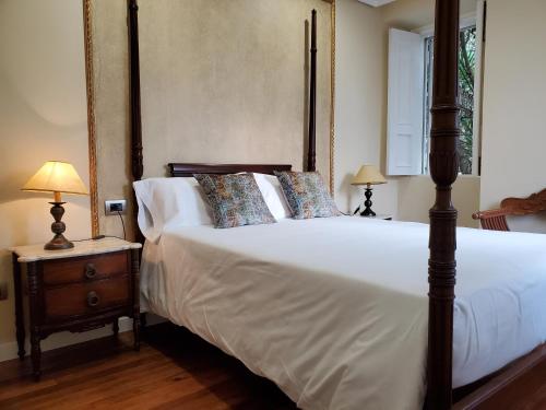 a bedroom with a large bed with white sheets and pillows at Hotel O'Pazo in Vigo