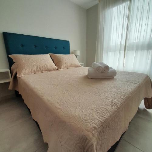 a bedroom with a large bed with two towels on it at Apart Clematis, 1 dormitorio céntrico con balcón. in Río Cuarto
