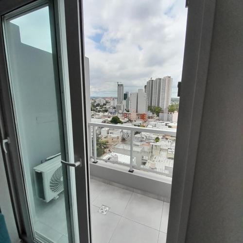 una puerta abierta a un balcón con vistas a la ciudad en Apart Clematis, 1 dormitorio céntrico con balcón. en Río Cuarto
