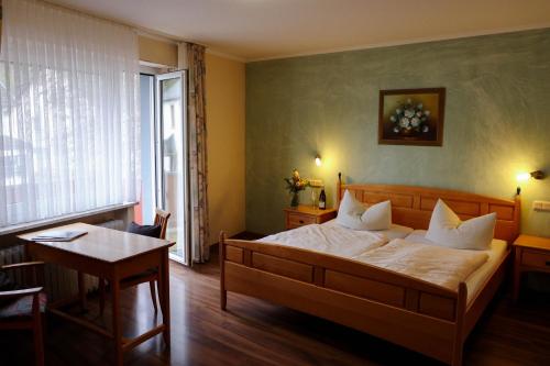 een slaapkamer met een bed, een tafel en een raam bij Hotel Kickert in Mettendorf