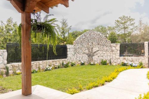 una pared de piedra en un jardín con patio en Casa Bonita en La Esperanza
