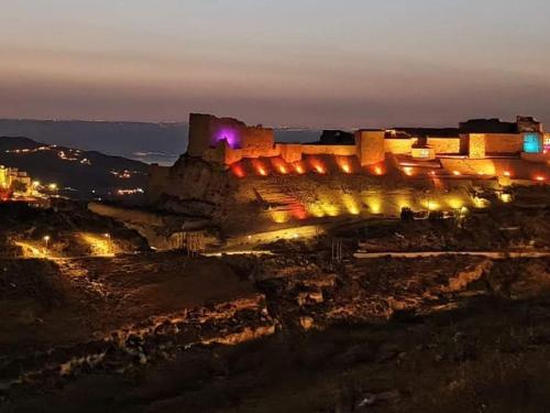 a view of a castle at night with lights at mountain view house in Kerak